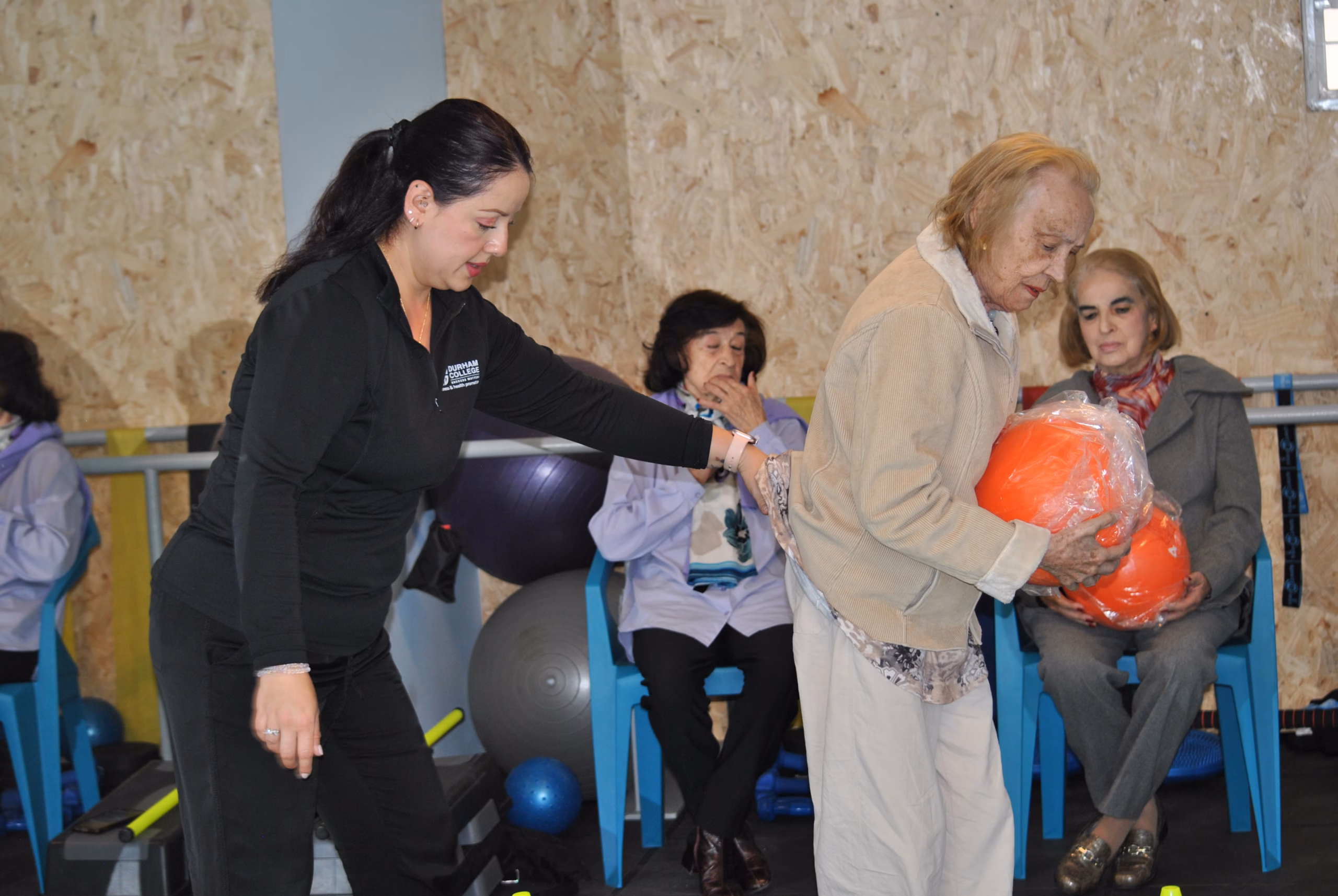 club-tiempo-vida-programa-vital-02 Instructor acompañando a un adulto mayor durante una sesión de movimiento en el programa Vital del Club Tiempo y Vida