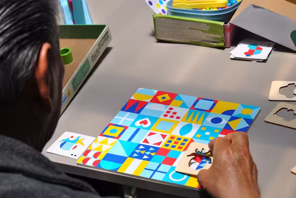 Adulto mayor armando un rompecabezas de estimulación cognitiva en el programa Mente Activa 360