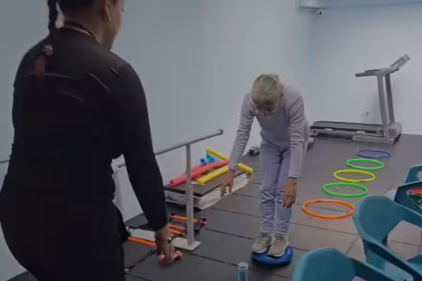 Adulto mayor haciendo ejercicio con apoyo de un instructor en el programa Vital: Movimiento y Energía